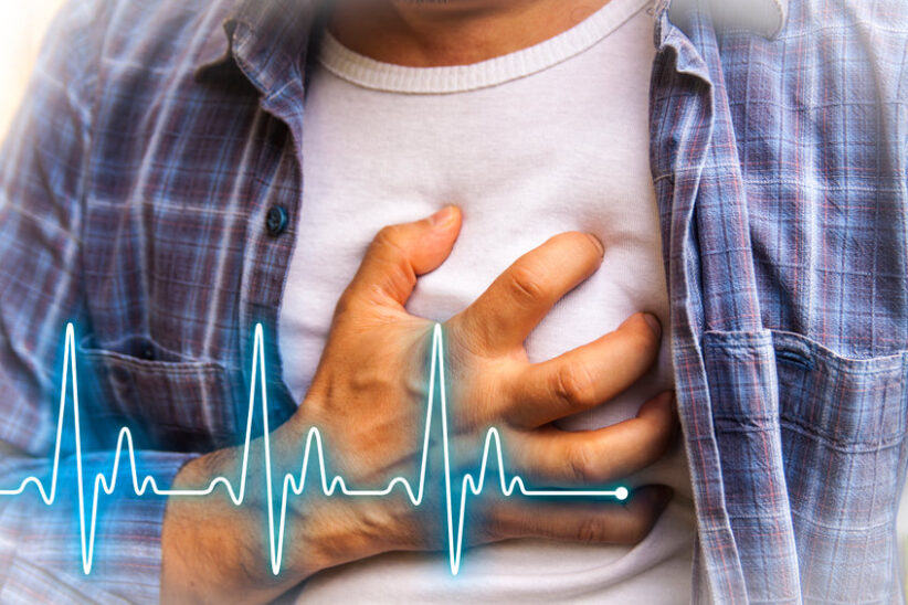Man in blue shirt having chest pain - heart attack - heartbeat line
