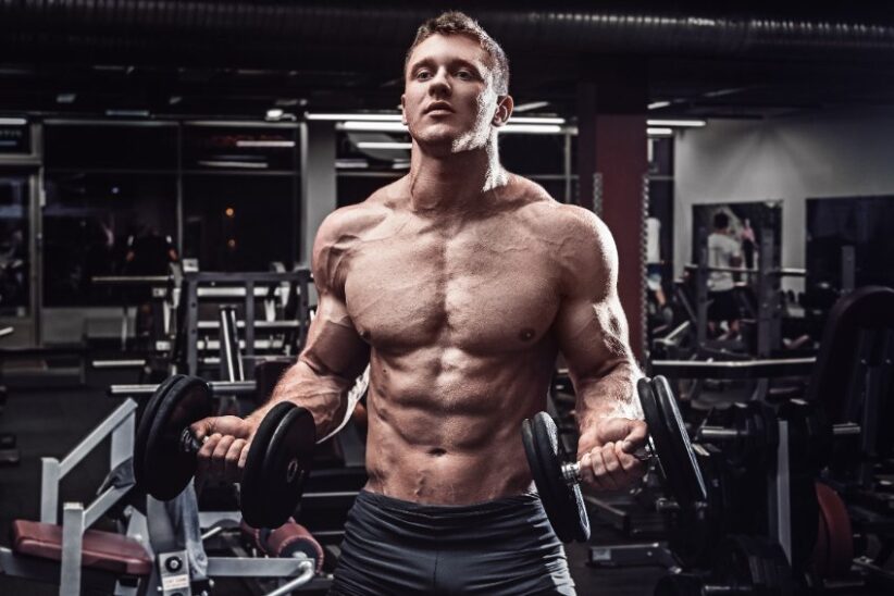 Man at gym with muscles bulging overtraining