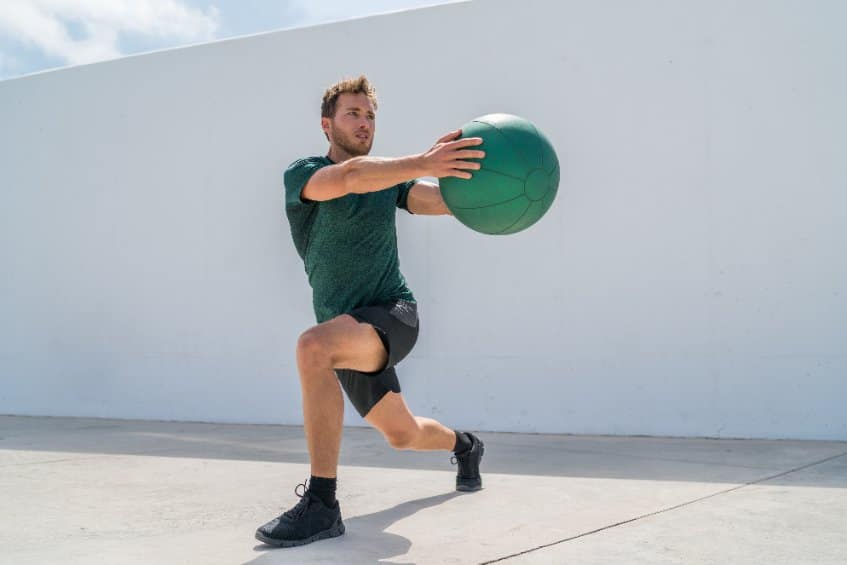 Man exercising with green weight ball