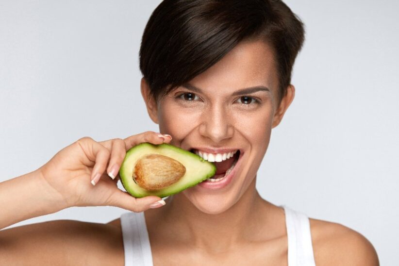 Woman eating an avocado